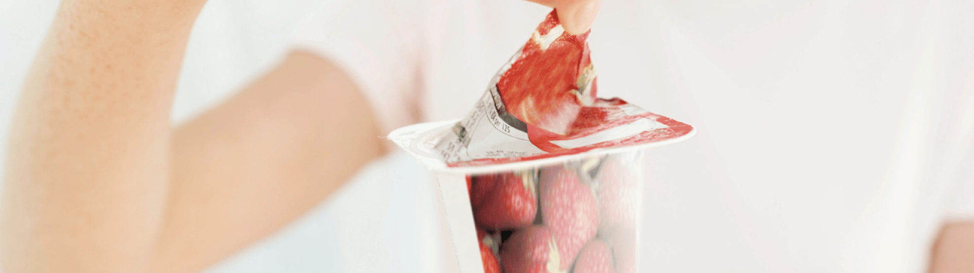 Person peeling open a yoghurt tub